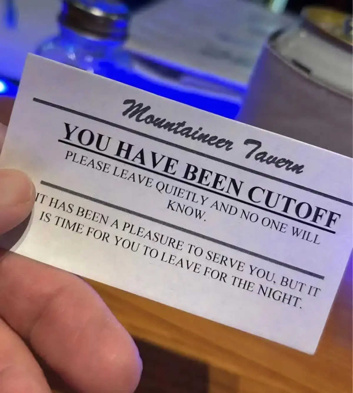 A hand holds a white card from 'Mountain Tavern' that reads 'YOU HAVE BEEN CUTOFF' in large bold letters, followed by…