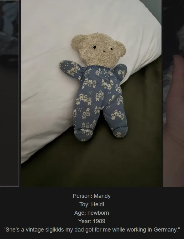 A beige teddy bear wearing blue pajamas with a repeating pattern of small cartoon figures lies on its back on a white pillow…