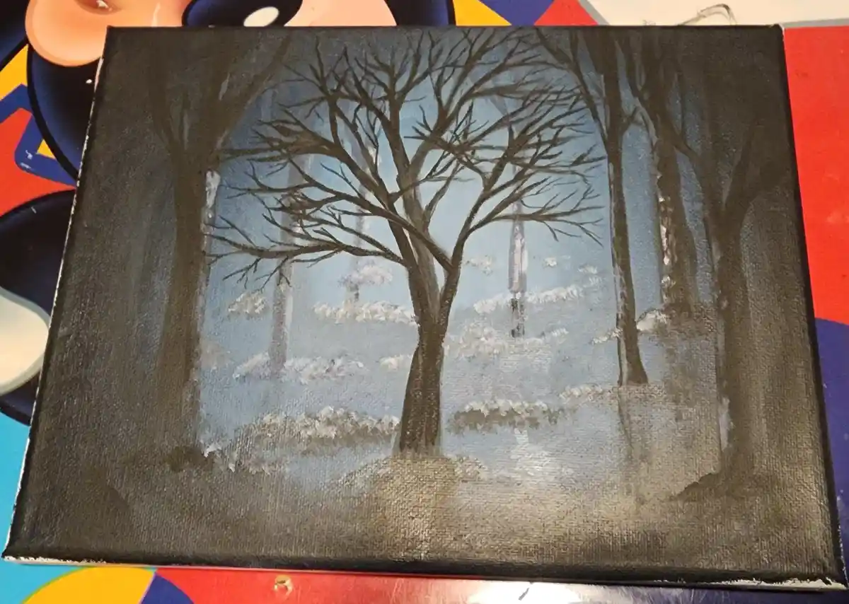 A hand-painted canvas depicts a winter forest scene with bare trees and snow-covered ground, but the trees are painted in…