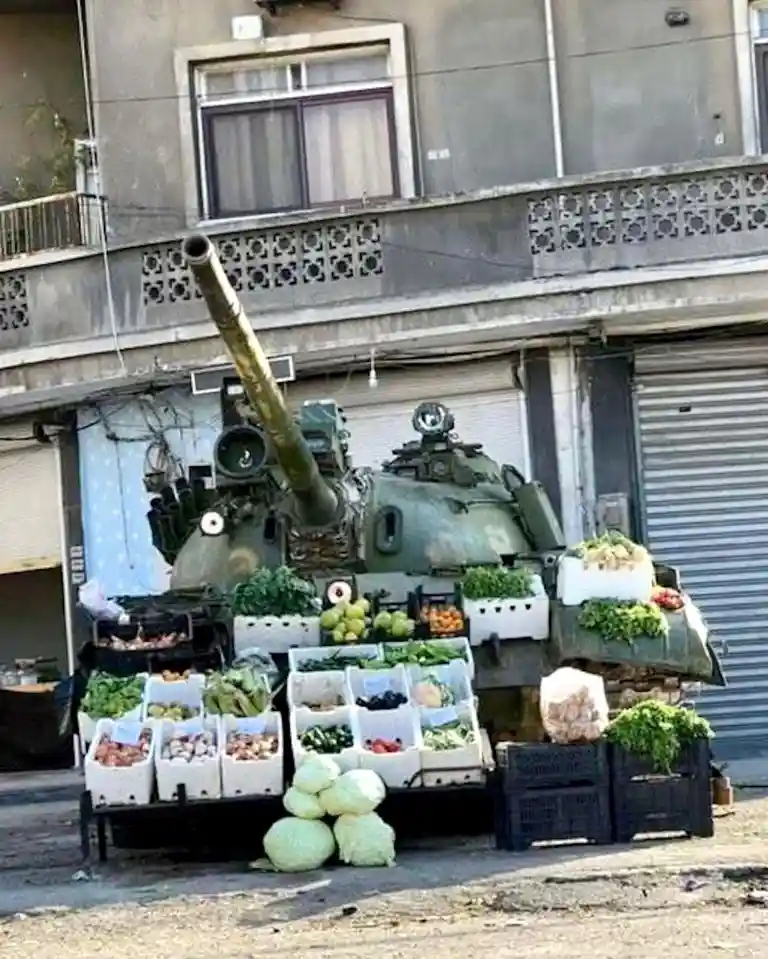 a military tank is parked on a street in front of a building, its turret and hull covered with white crates filled with…