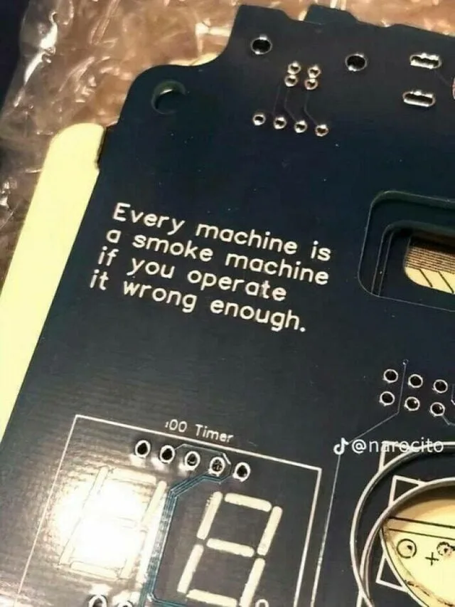 A close-up photo of a black electronic circuit board with white text that reads 'Every machine is a smoke machine if you…