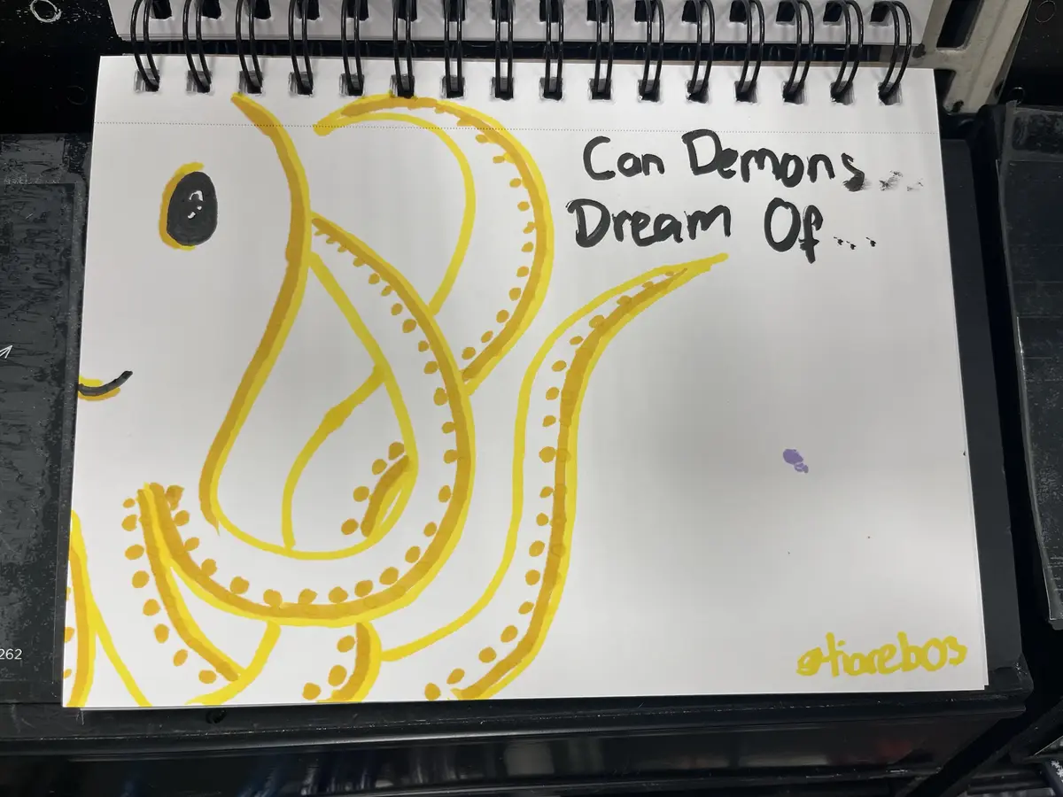 A hand-drawn image on a spiral-bound notebook page shows a yellow, cartoonish octopus with one visible eye and a smiling…
