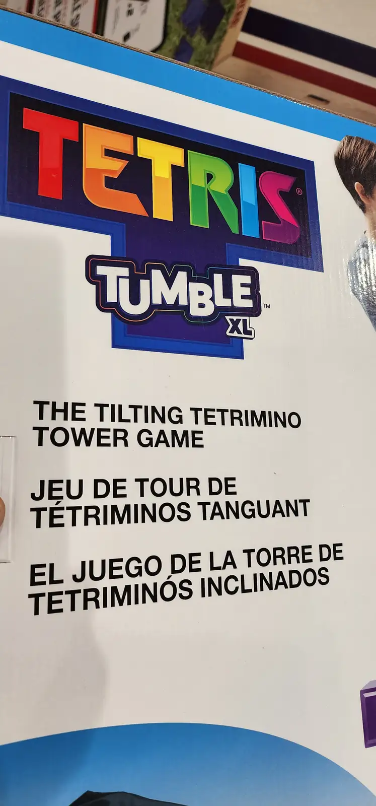 A close-up of a Tetris Tumble XL game box showing the colorful Tetris logo and the tagline 'THE TILTING TETRIMINO TOWER…