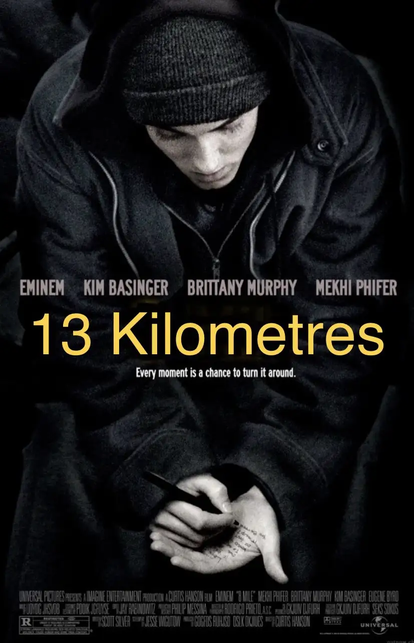 A black-and-white movie poster for '13 Kilometres' featuring a young man in a hoodie and beanie, looking down while writing…