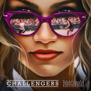 A promotional image for the movie 'Challengers' featuring a close-up of a woman with purple cat-eye glasses. The lenses…
