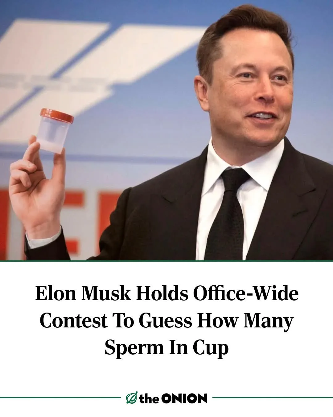 A man in a dark suit and tie holds up a small, clear plastic cup with a red lid, which contains a white substance. The image…