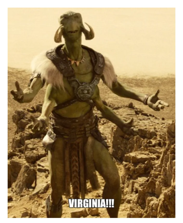 A green-skinned, horned alien creature from the movie 'Avatar' stands in a desert-like rocky terrain with arms outstretched…