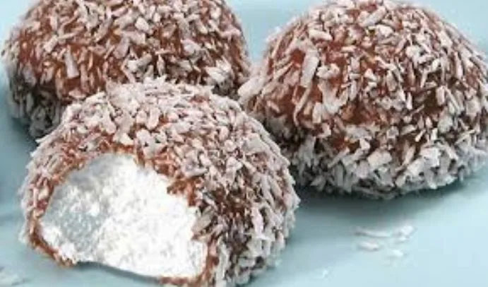 Three chocolate-coated coconut-covered balls, one bitten open to reveal a white, powdery interior, with the text 'what's…