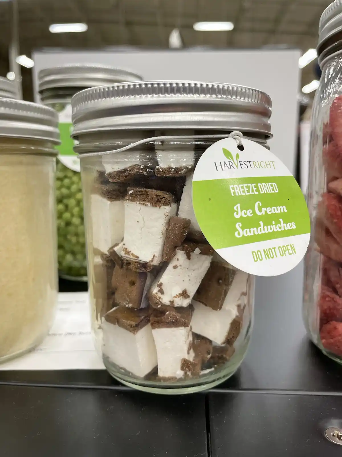 A glass jar filled with freeze-dried ice cream sandwiches, labeled 'FREEZE DRIED Ice Cream Sandwiches DO NOT OPEN' by…