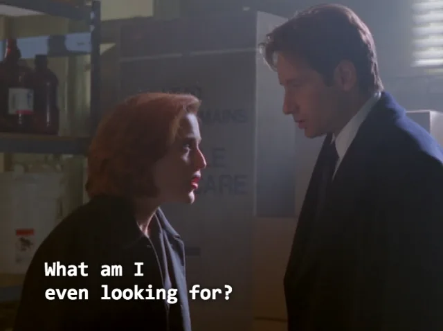 A still from the movie 'The Matrix' shows a woman with red hair and a man in a suit standing in a dimly lit room with…