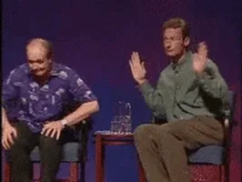 A sequence of six frames shows a man in a green shirt sitting in a chair on a stage, initially gesturing with both hands…