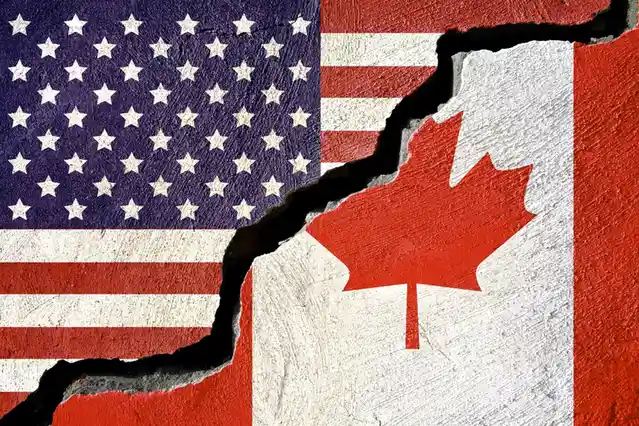 The image shows a textured wall painted with the American flag on the left and the Canadian flag on the right, separated by…