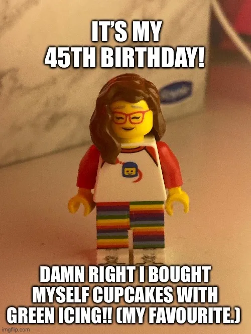 A close-up photo of a female LEGO minifigure with brown hair, red glasses, and a rainbow-striped outfit. The image has bold…